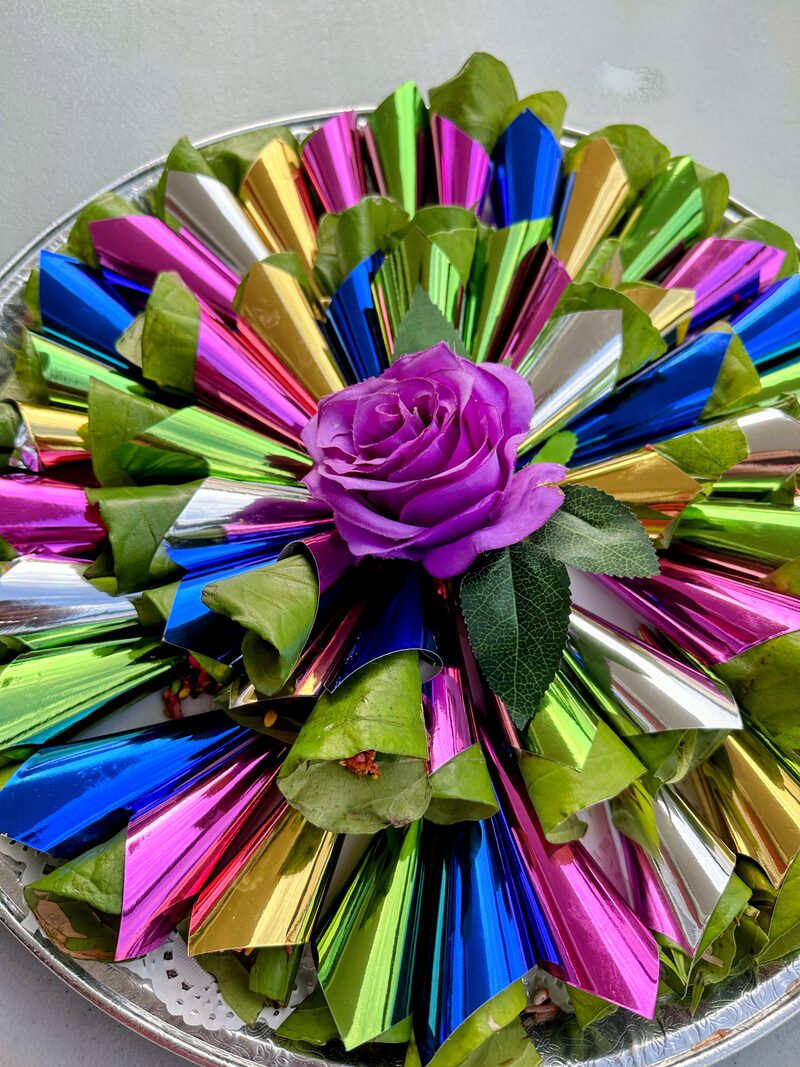 Colourful foil paan tray with purple rose centrepiece